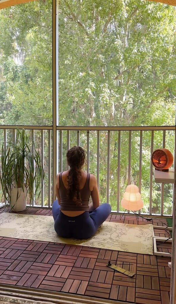 Quiet balcony meditation facing greenery — health, wellness, and calm in daily rhythm